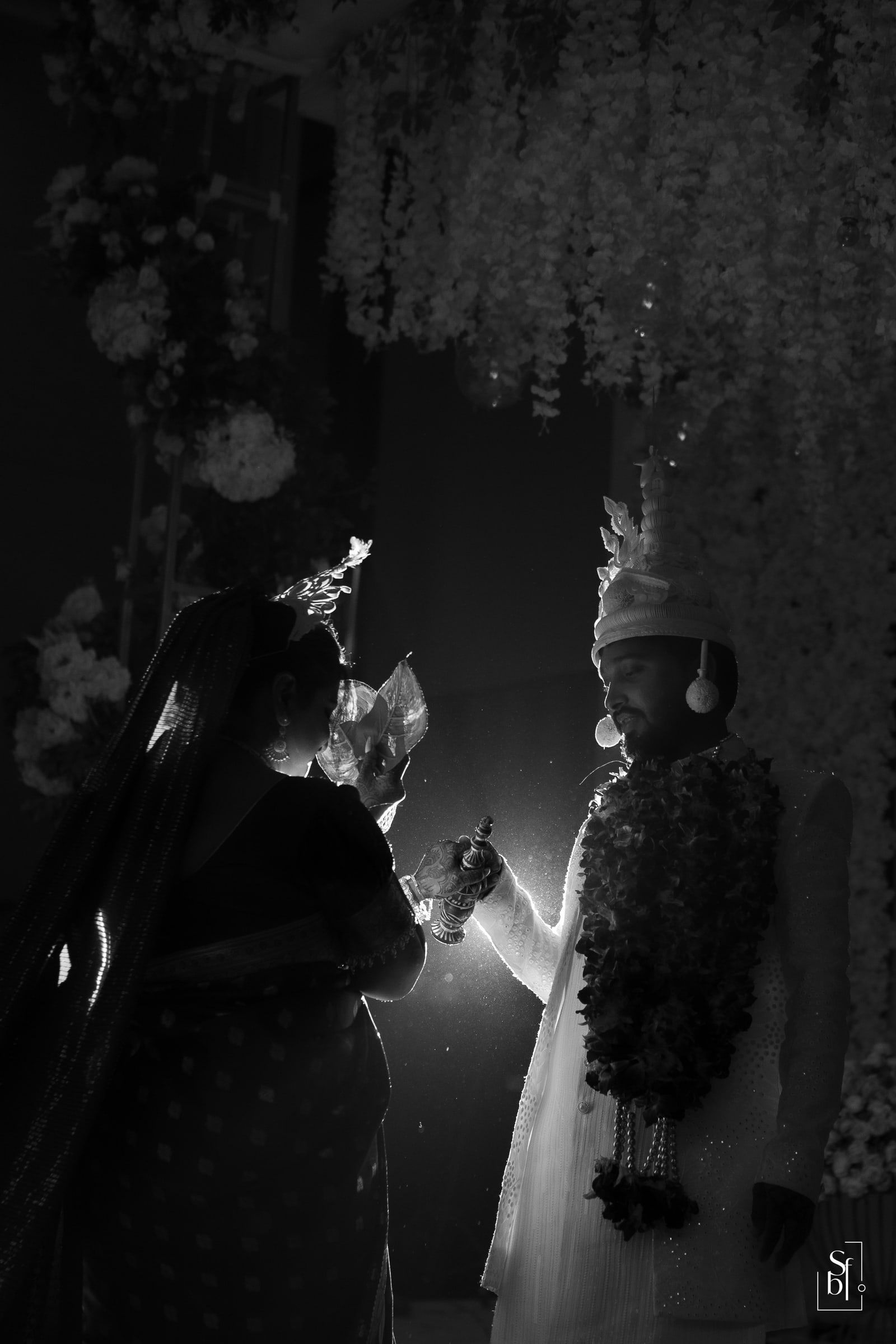 Backlit black-and-white frame of a couple during the wedding ceremony